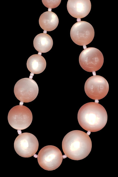 Detail view of 1960s vintage long pink moonglow Lucite graduated bead necklace. Showing a close-up of the center front beads. 