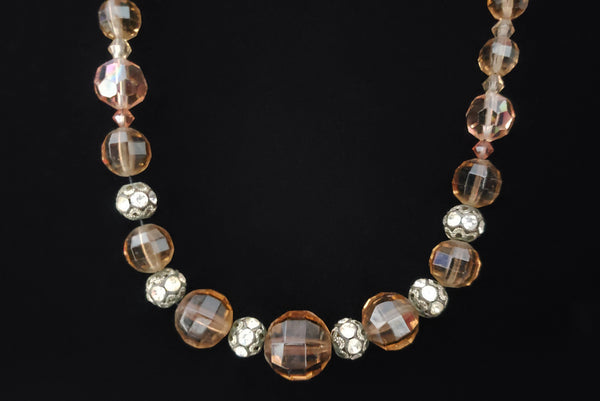 Detail view of 1960s vintage smokey topaz mauve graduated crystal bead and silver tone rhinestone spacer long necklace. Showing the silver tone and rhinestone balls in between the faceted crystal beads.
