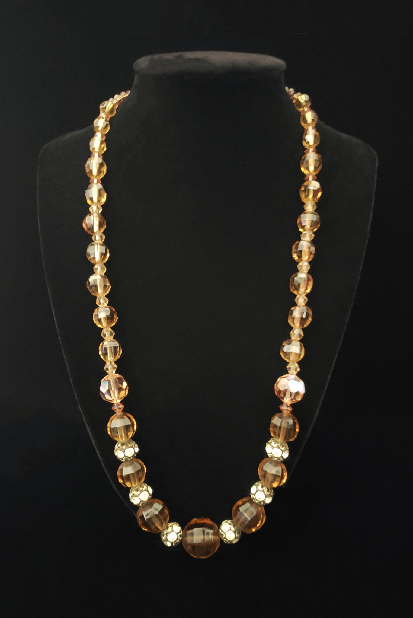 Vertical front view of 1960s vintage smokey topaz mauve graduated crystal bead and silver tone rhinestone spacer long necklace.