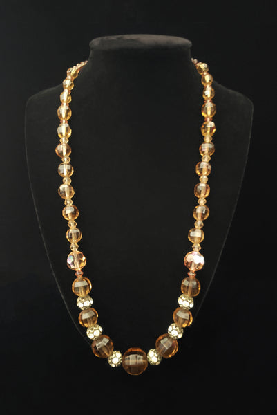 Vertical front view of 1960s vintage smokey topaz mauve graduated crystal bead and silver tone rhinestone spacer long necklace.