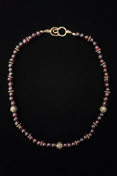 Vertical view of 1970s vintage dark red garnet and brass beaded necklace.