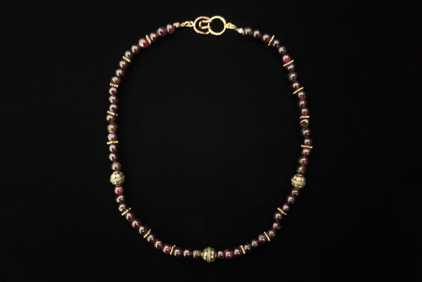 Horizontal view of 1970s vintage dark red garnet and brass beaded necklace.