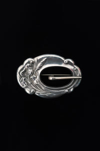 Vertical front view of 1900s vintage turn of the century 925 sterling silver iris floral sash buckle brooch.