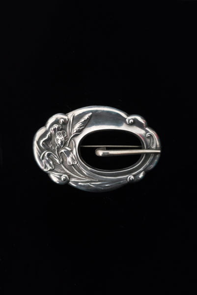 Vertical front view of 1900s vintage turn of the century 925 sterling silver iris floral sash buckle brooch.