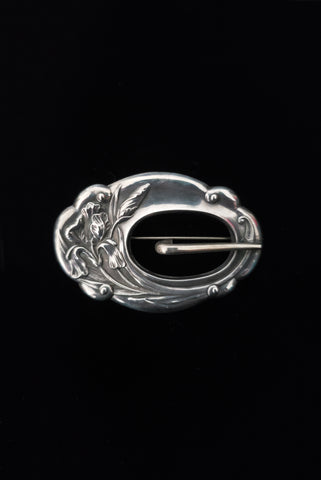 Vertical front view of 1900s vintage turn of the century 925 sterling silver iris floral sash buckle brooch.