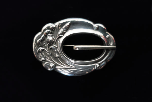 Horizontal front view of 1900s vintage turn of the century 925 sterling silver iris floral sash buckle brooch.