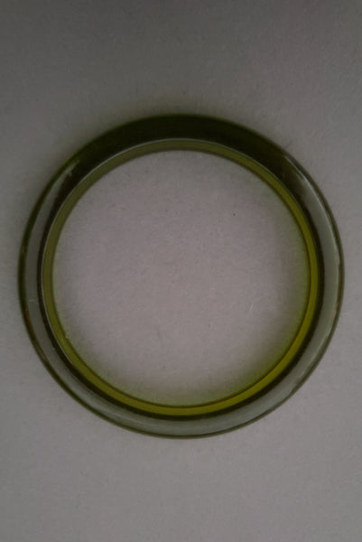 Vertical top view of 1930s vintage prystal translucent green domed plastic Bakelite bangle bracelet.