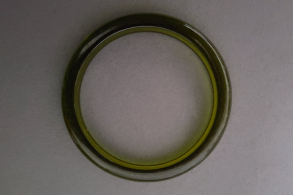 Horizontal top view of 1930s vintage prystal translucent green domed plastic Bakelite bangle bracelet.