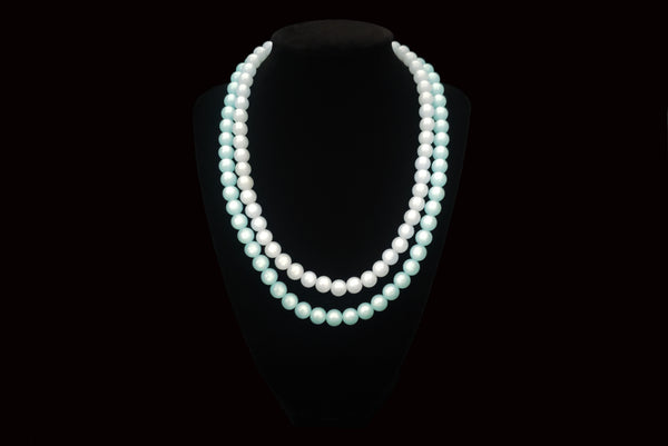 Horizontal view of 1960s vintage double strand moonglow Lucite two tone blue adjustable necklace. Showing the necklace on a display.