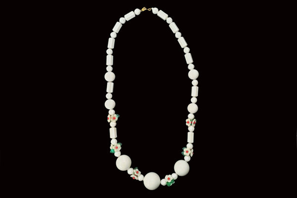 Horizontal view of 1960s vintage green, red, and white floral bead plastic long necklace.