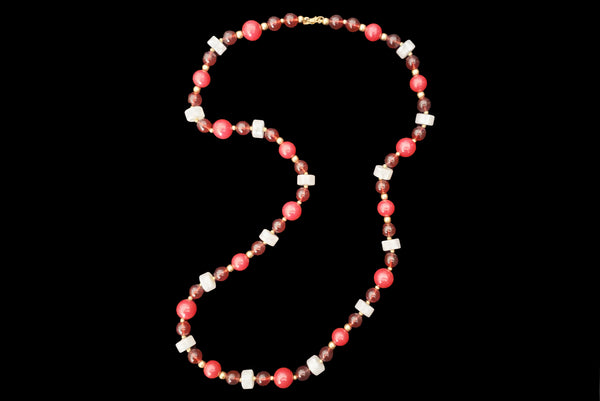 Vertical view of 1960s vintage red & white Lucite plastic beaded long necklace with gold tone spacers by Monet.