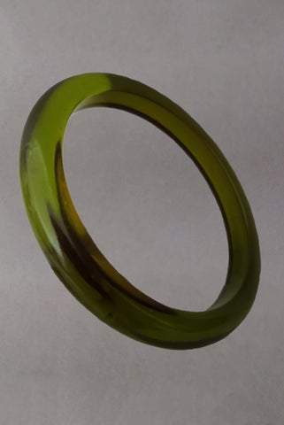 Vertical perspective view of 1930s vintage prystal translucent green domed plastic Bakelite bangle bracelet.