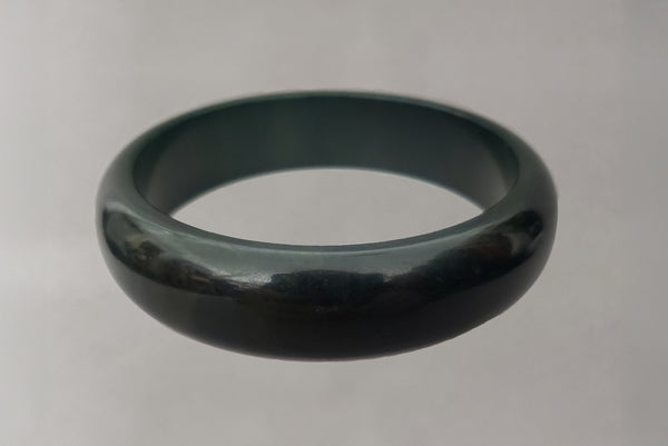 Horizontal front view of 1930s vintage dark blue moon, marbled green and blue Bakelite bangle bracelet.