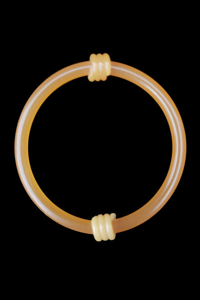 Vertical top view of 1960s vintage translucent mustard yellow plastic tube bangle bracelet with wrapped phone cord detailing.