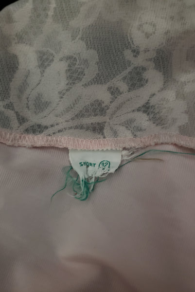 Interior detail view of 1960s vintage pale pink nylon and gray lace full slip, extra small to small. Showing the 32 short size tag.