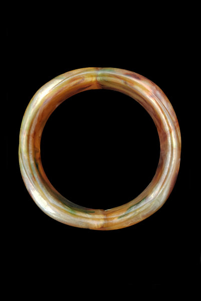 Vertical top view of 1980s vintage pearly green and brown molded plastic bangle bracelet.