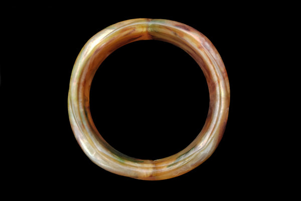 Horizontal top view of 1980s vintage pearly green and brown molded plastic bangle bracelet.