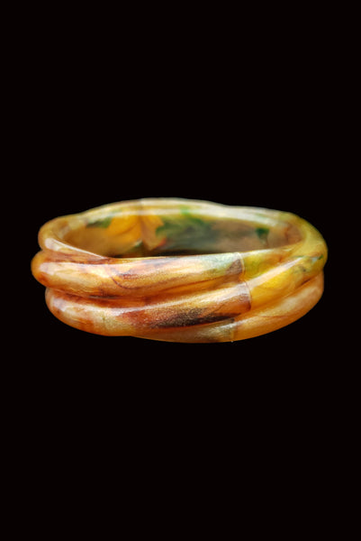 Vertical front view of 1980s vintage pearly green and brown molded plastic bangle bracelet.