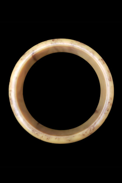 Vertical top view of 1930s vintage cream corn yellow and chocolate brown marbled Bakelite bangle bracelet.