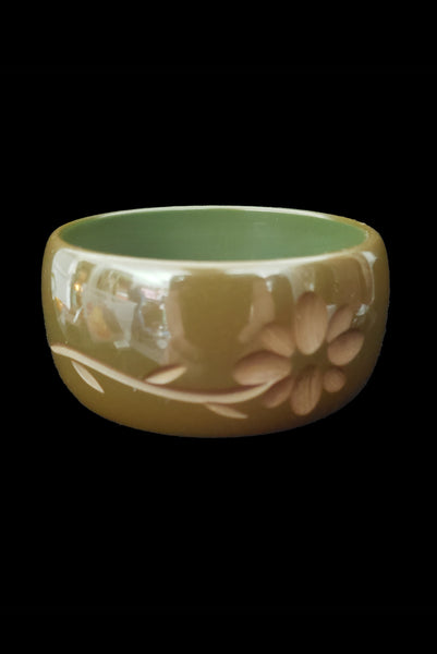 Vertical front view of 1930s vintage green floral carved Bakelite bangle bracelet.
