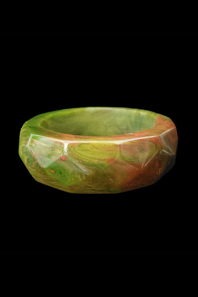 Vertical front view of 1940s vintage chunky green and red marbled facet carved Bakelite bangle bracelet.