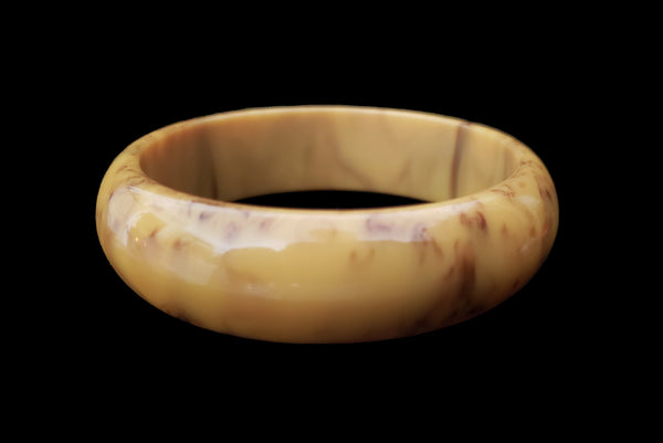 Horizontal front view of 1930s vintage cream corn yellow and chocolate brown marbled Bakelite bangle bracelet.