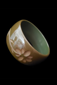 Vertical perspective view of 1930s vintage green floral carved Bakelite bangle bracelet.