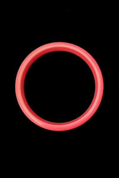 Vertical top view of 1980s vintage coral pink plastic bangle bracelet set of three (3). Showing the darkest bangle on its own.