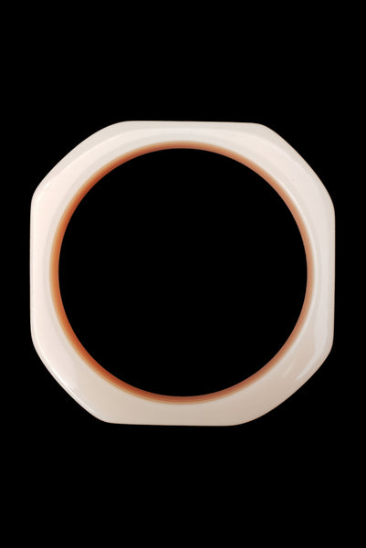 Vertical top view of 1980s vintage orange and white square sliced polka dot, striped, and translucent solid three (3) bangle bracelet set. Showing the orange with white striped layered bangle alone.