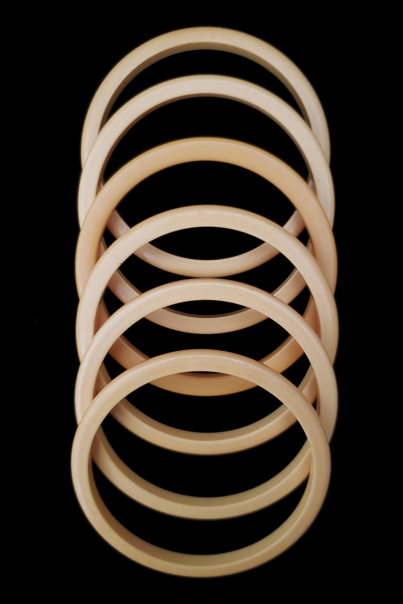 Vertical top view of 1930s vintage set of six (6) corn mustard yellow Bakelite spacer bangle bracelets.