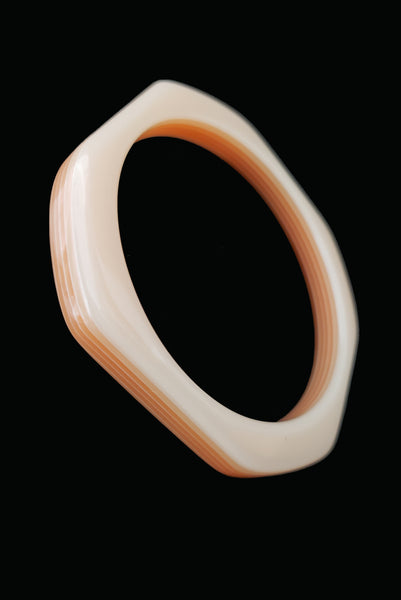 Vertical perspective view of 1980s vintage orange and white square sliced polka dot, striped, and translucent solid three (3) bangle bracelet set. Showing the orange with white striped layered bangle alone.