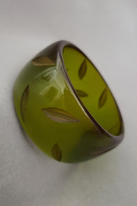 Vertical perspective view of 1930s vintage statement leaf carved prystal green Bakelite bangle bracelet.