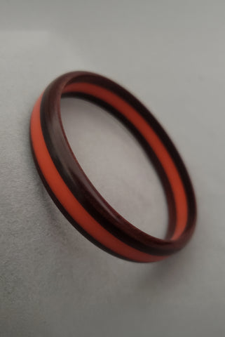 Vertical perspective view of 1940s vintage three layer orange and brown faux wood laminated Bakelite bangle bracelet.
