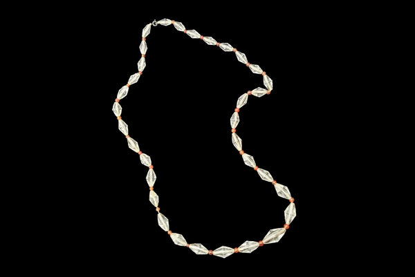 Horizontal view of 1920s vintage graduated bicone clear crystal bead necklace with orange amber colored round glass spacers.