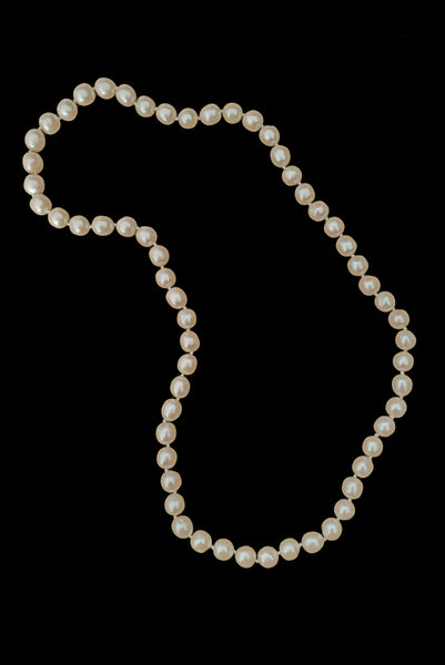 Vertical view of 1980s vintage cream faux pearl long beaded necklace.