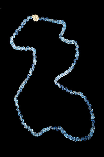 Vertical front view of 1980s vintage blue faceted round crystal long beaded necklace with silver tone rose clasp.