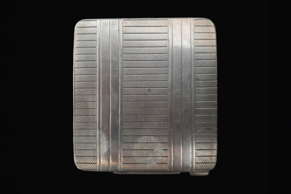 Horizontal bottom view of 1920s vintage square silver tone stripe engraved make-up compact.