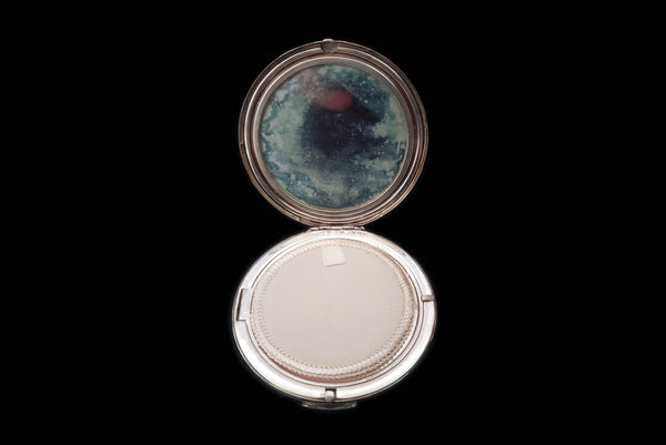 Horizontal open view of 1950s vintage round sterling silver Aztec calendar engraved make-up compact. Showing the mirror that has gone cloudy from age.