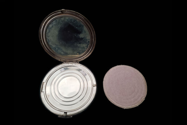 Horizontal open view of 1950s vintage round sterling silver Aztec calendar engraved make-up compact. Showing the clean powder puff.