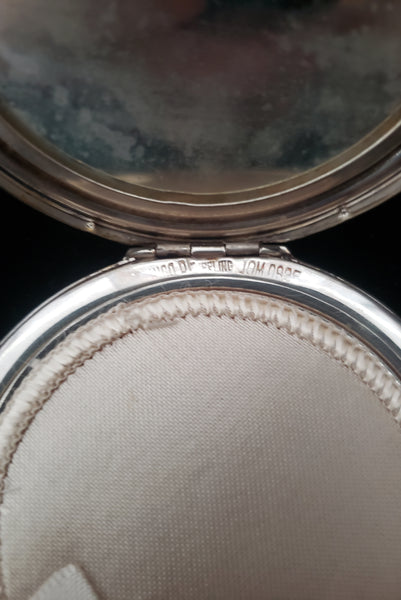 Detail view of 1950s vintage round sterling silver Aztec calendar engraved make-up compact. Showing the sterling silver stamp and the maker's mark.