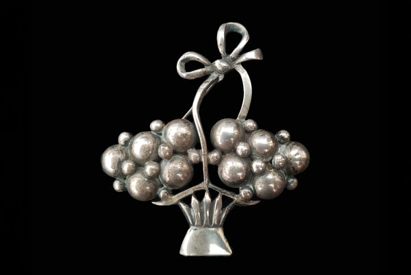 Horizontal front view of 1920s vintage 925 sterling silver modernist flower basket brooch.
