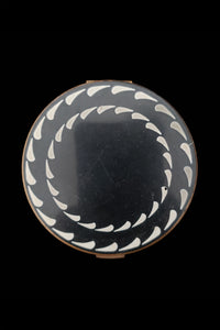 Vertical top view of 1930s vintage Art Deco black and white enamel round gold metal mesh make-up compact by Elgin.