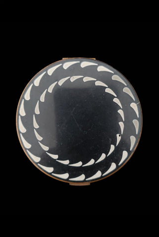 Vertical top view of 1930s vintage Art Deco black and white enamel round gold metal mesh make-up compact by Elgin.