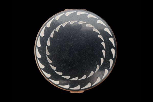 Horizontal top view of 1930s vintage Art Deco black and white enamel round gold metal mesh make-up compact by Elgin.