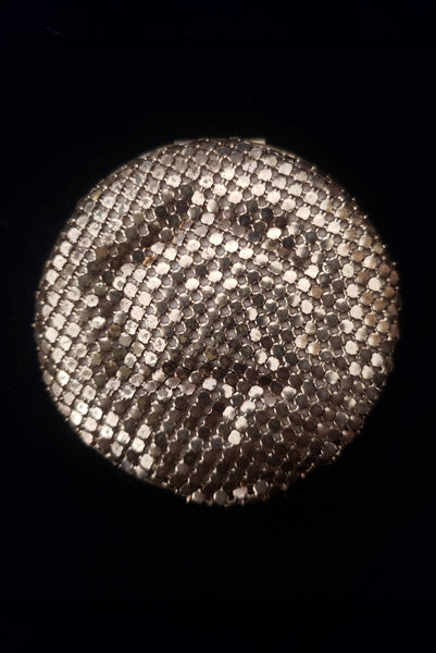 Vertical bottom view of 1930s vintage Art Deco black and white enamel round gold metal mesh make-up compact by Elgin.