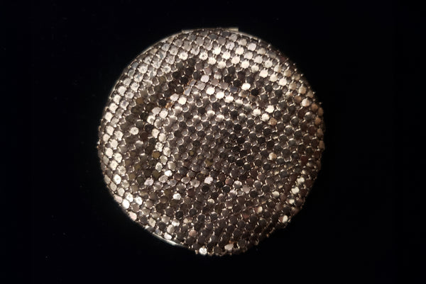 Horizontal bottom view of 1930s vintage Art Deco black and white enamel round gold metal mesh make-up compact by Elgin.