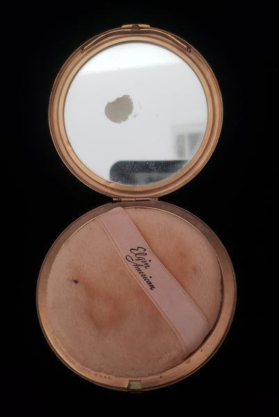 Vertical open view of 1930s vintage Art Deco black and white enamel round gold metal mesh make-up compact by Elgin. Showing an age spot on the mirror.