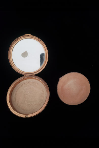 Vertical open view of 1930s vintage Art Deco black and white enamel round gold metal mesh make-up compact by Elgin. Showing the powder puff removed and the vintage powder covered by a fabric screen.