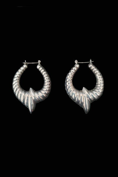 Vertical side view of 1980s vintage 925 sterling silver hollow cast large pointed hoop earrings.