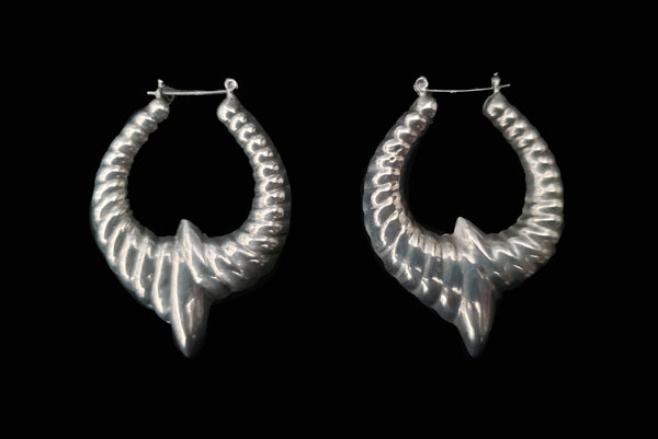 Horizontal side view of 1980s vintage 925 sterling silver hollow cast large pointed hoop earrings.